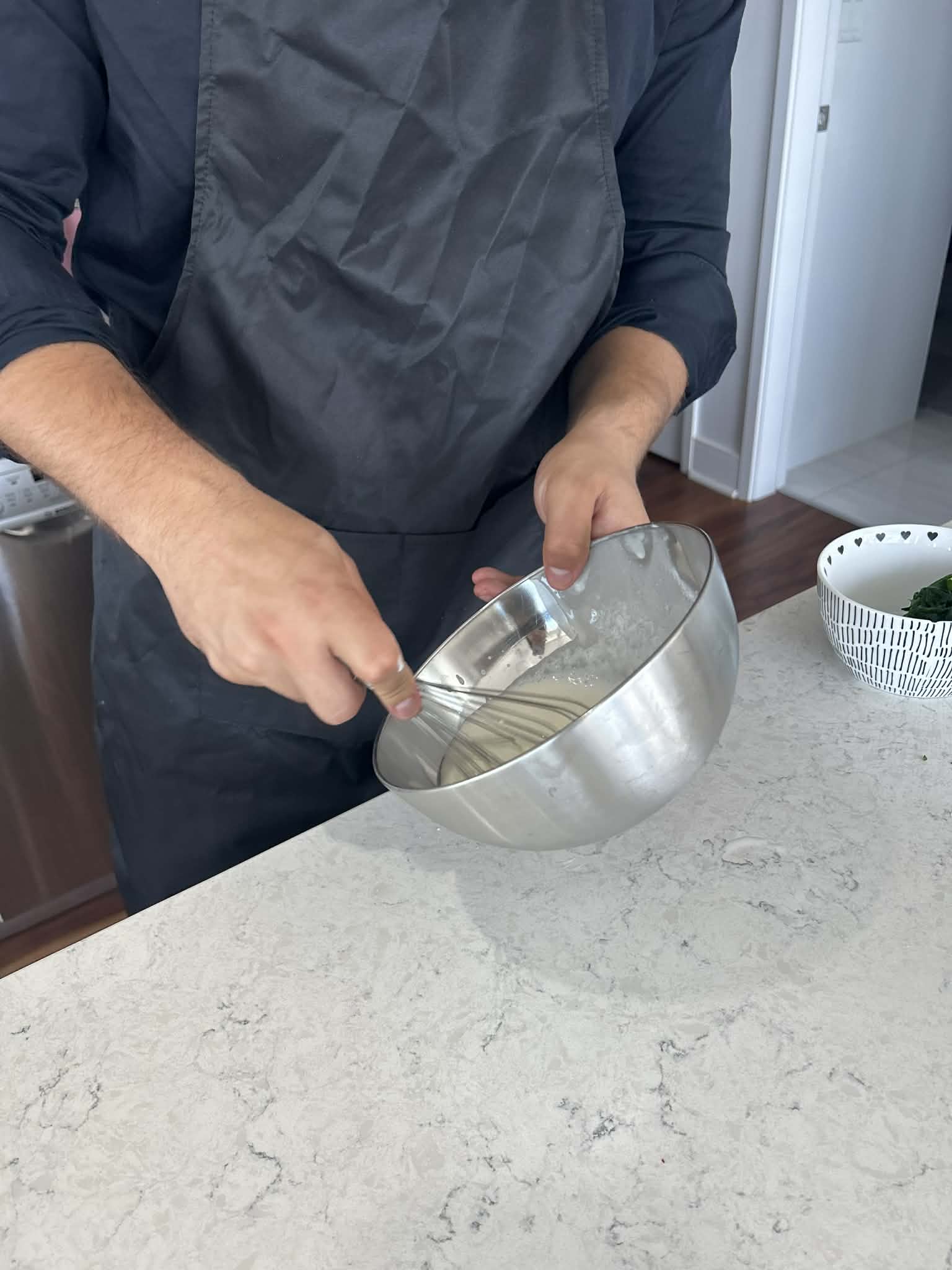 Chef Neil whisking a sauce in the kitchen