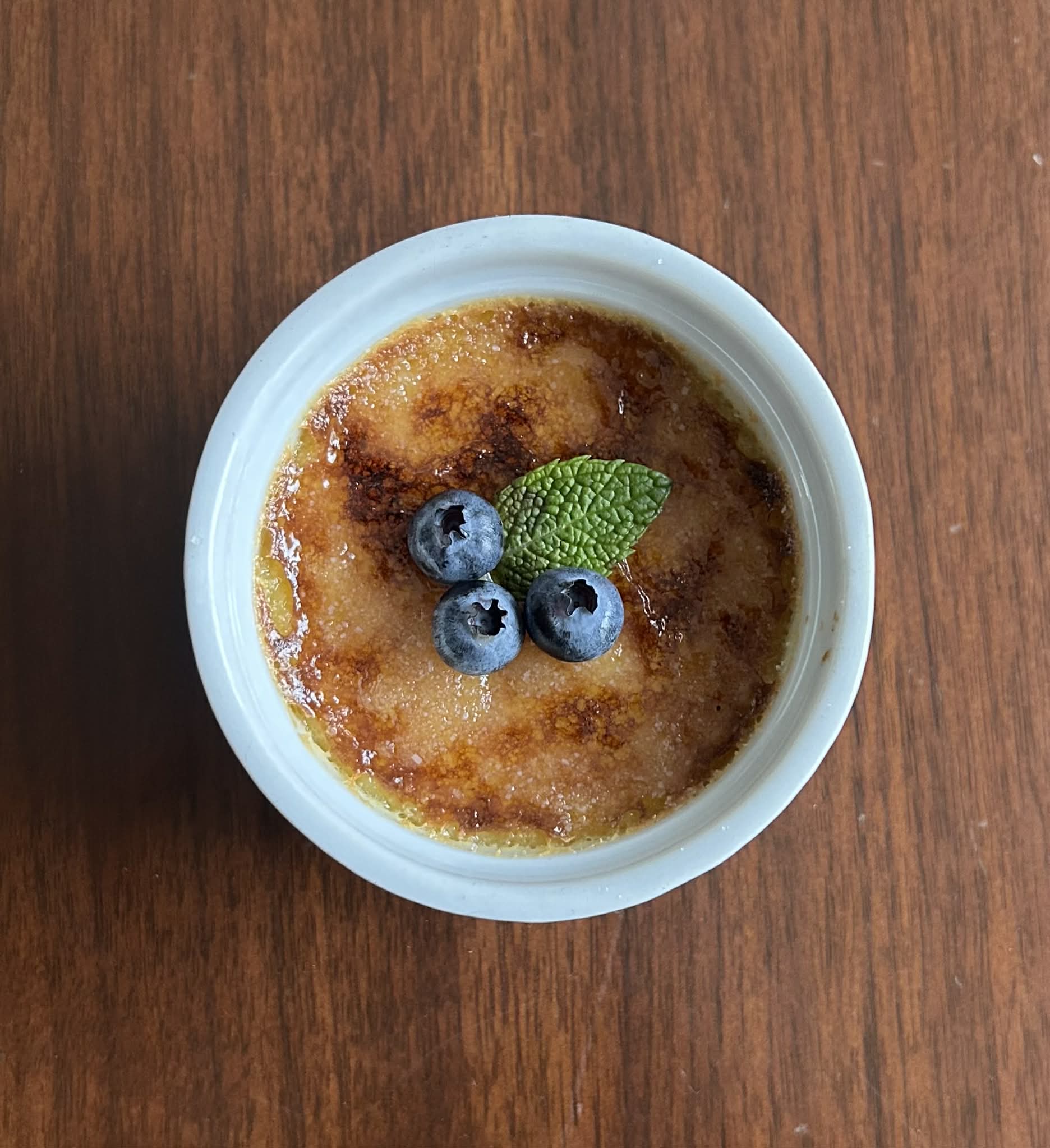 Creme brulee topped with fresh blueberries and mint