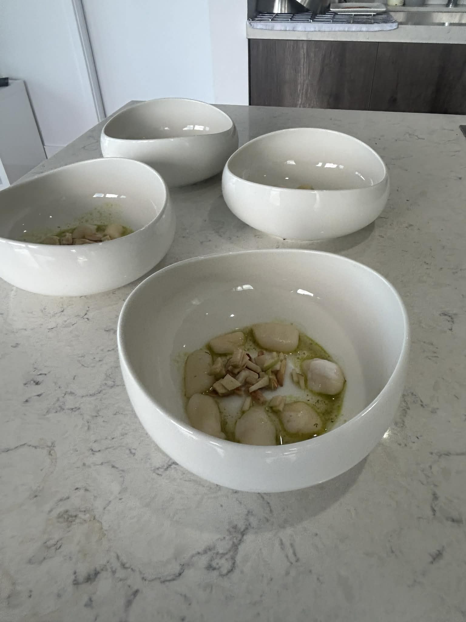 Scallops being prepared with herb oil